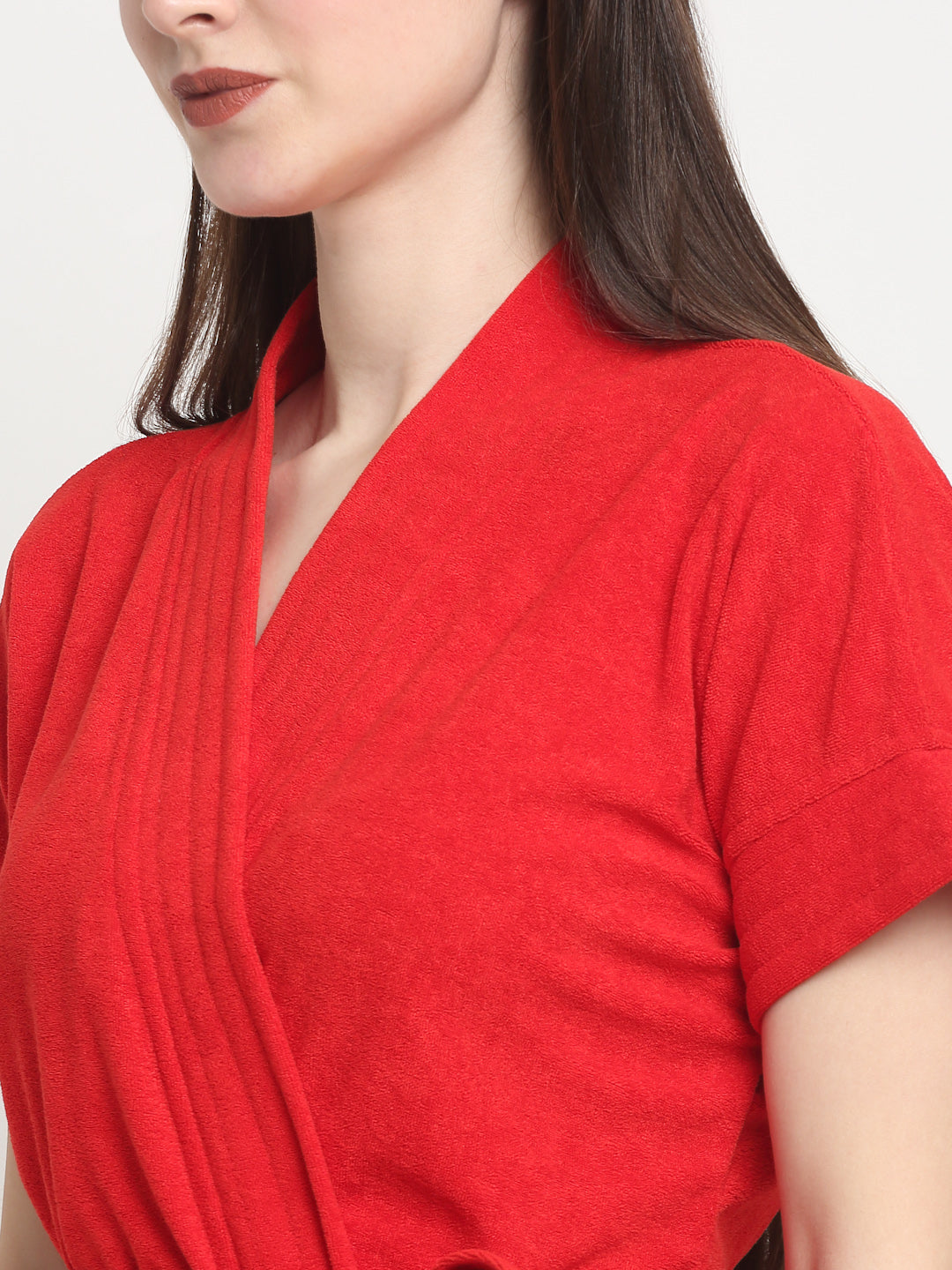 Close-up of a woman wearing a red micro terry bathrobe with a tie belt