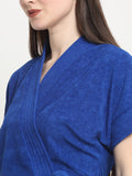 Close-up of a woman wearing a royal blue micro terry bathrobe with a tie belt