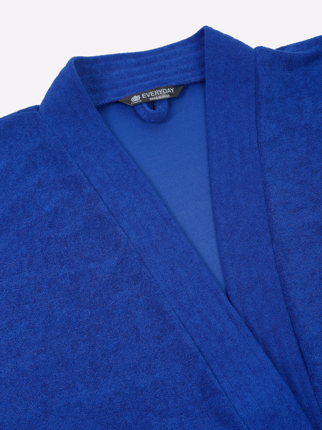 Close-up of a royal blue micro terry bathrobe showing the collar and fabric texture