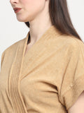 Close-up of a woman wearing a rust micro terry bathrobe with a tie belt