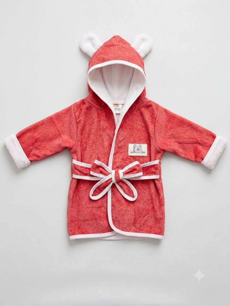 A coral red hooded bathrobe with white trim, featuring a tie belt, white faux-fur trimmed cuffs, and white bear-ear hood details, laid flat on a light gray background.