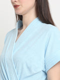 Close-up of a woman wearing a sky-blue micro terry bathrobe with a tie belt