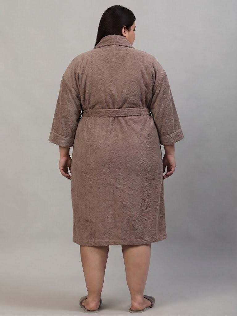 A person shown from the back wearing a brown bathrobe against a plain light gray studio background.
