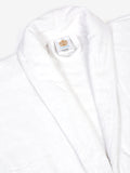 Close-up of a white cotton bathrobe showing the collar and fabric texture