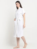 A Woman wearing a white micro terry bathrobe with a tie belt