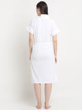 Back view of a woman wearing a white micro terry bathrobe with a tie belt