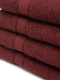 4 Stacked wine cotton towels with textured terry fabric and decorative stripe detailing.