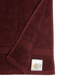 Wine cotton hand towel showing a close-up of the terry texture, decorative stripe detailing, and CREEVA label.