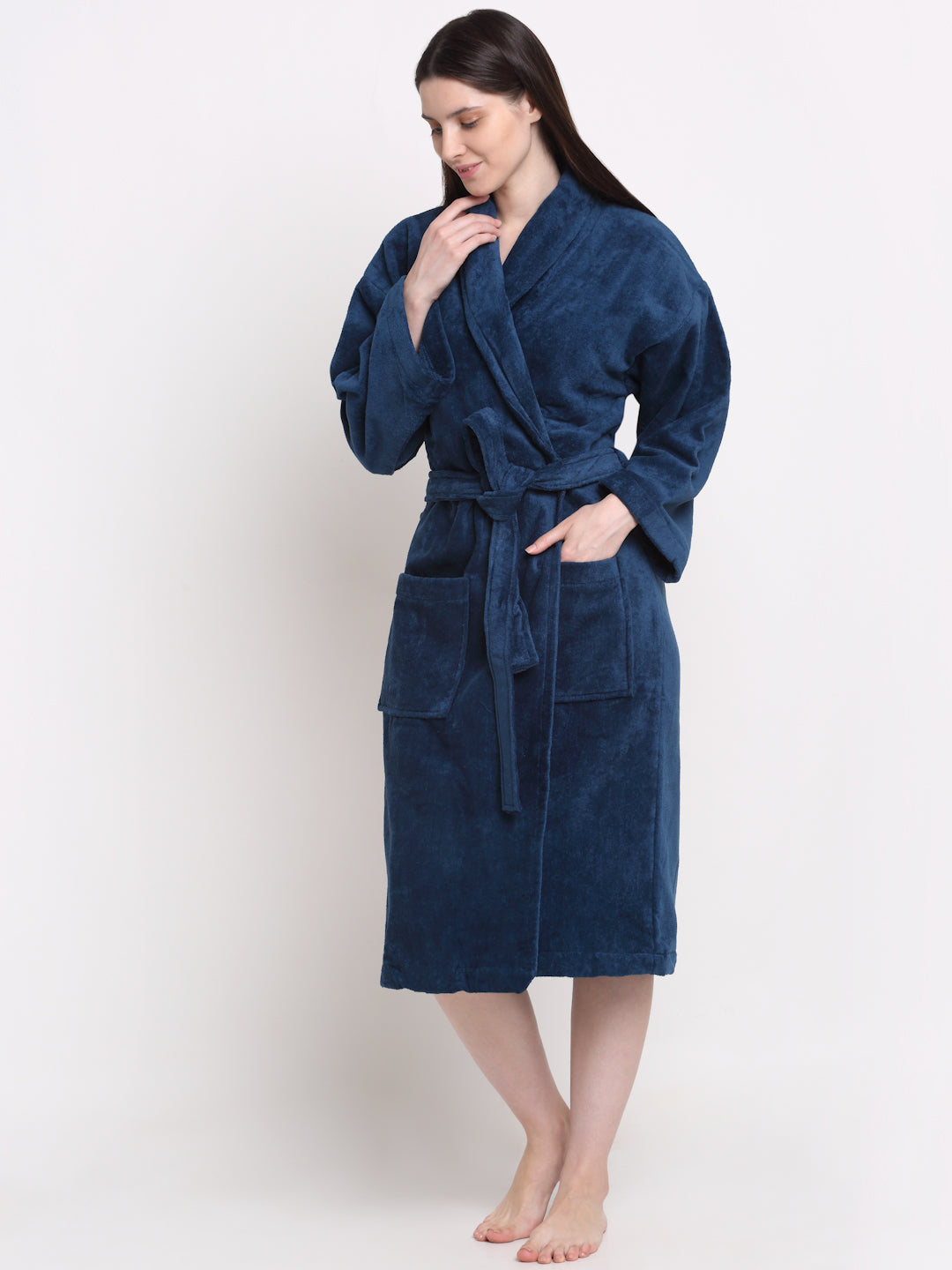 A person standing by a chair wearing a blue cotton bathrobe with a relaxed fit.
