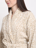 Close-up of a woman wearing a cream and rust cotton bathrobe with a shawl collar and waist belt