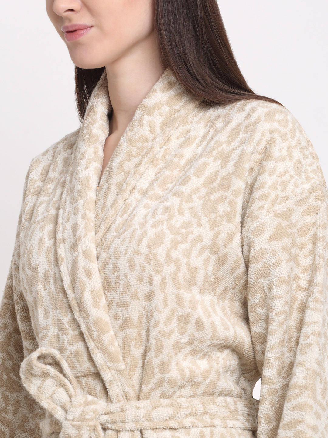 Close-up of a woman wearing a cream and rust cotton bathrobe with a shawl collar and waist belt