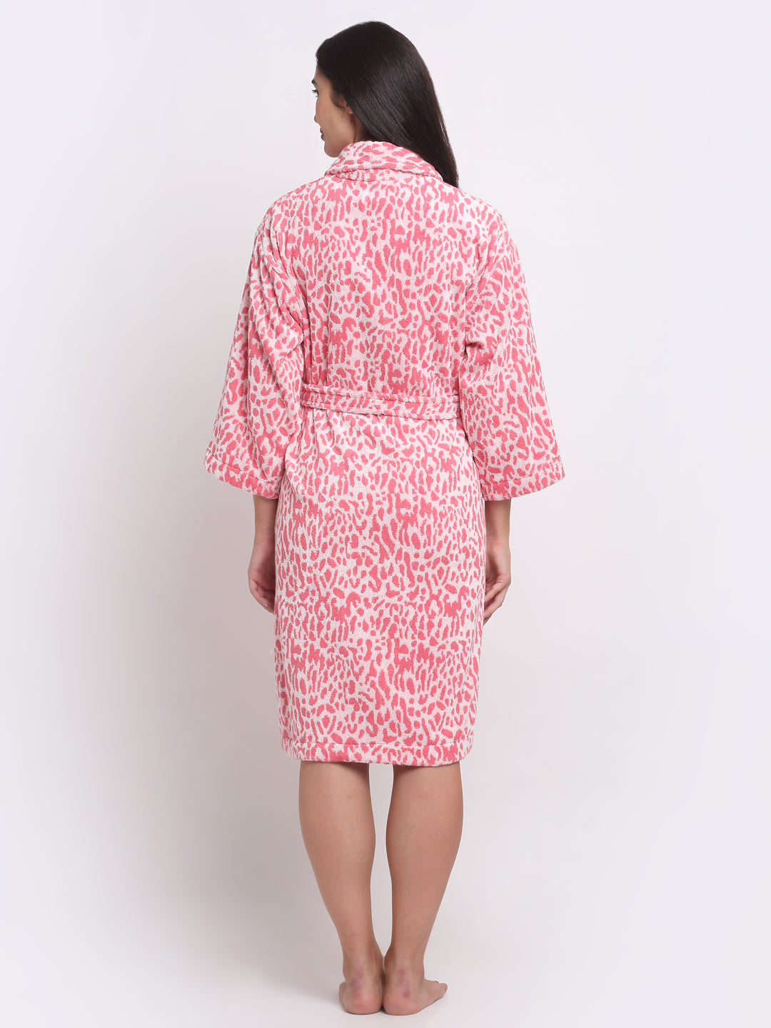 Back view of a woman wearing a pink leopard bathrobe with a waist belt