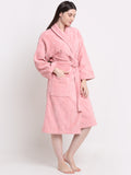 Woman wearing a pink 100% cotton bathrobe with a waist belt and front pockets