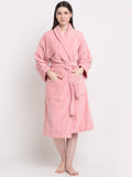 A person wearing a pink unisex cotton bathrobe and standing 