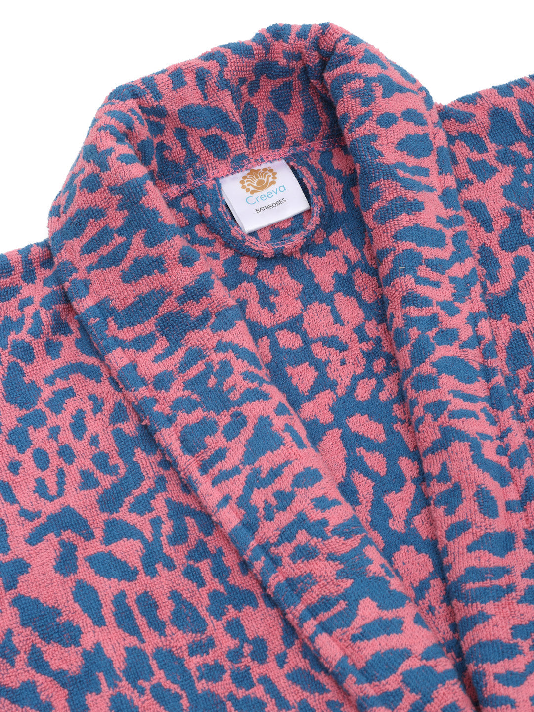 Close-up of a pink and blue cotton bathrobe showing the shawl collar, soft terry texture, and CREEVA label