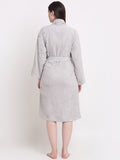 Back view of a woman wearing a silver cotton bathrobe with a waist belt