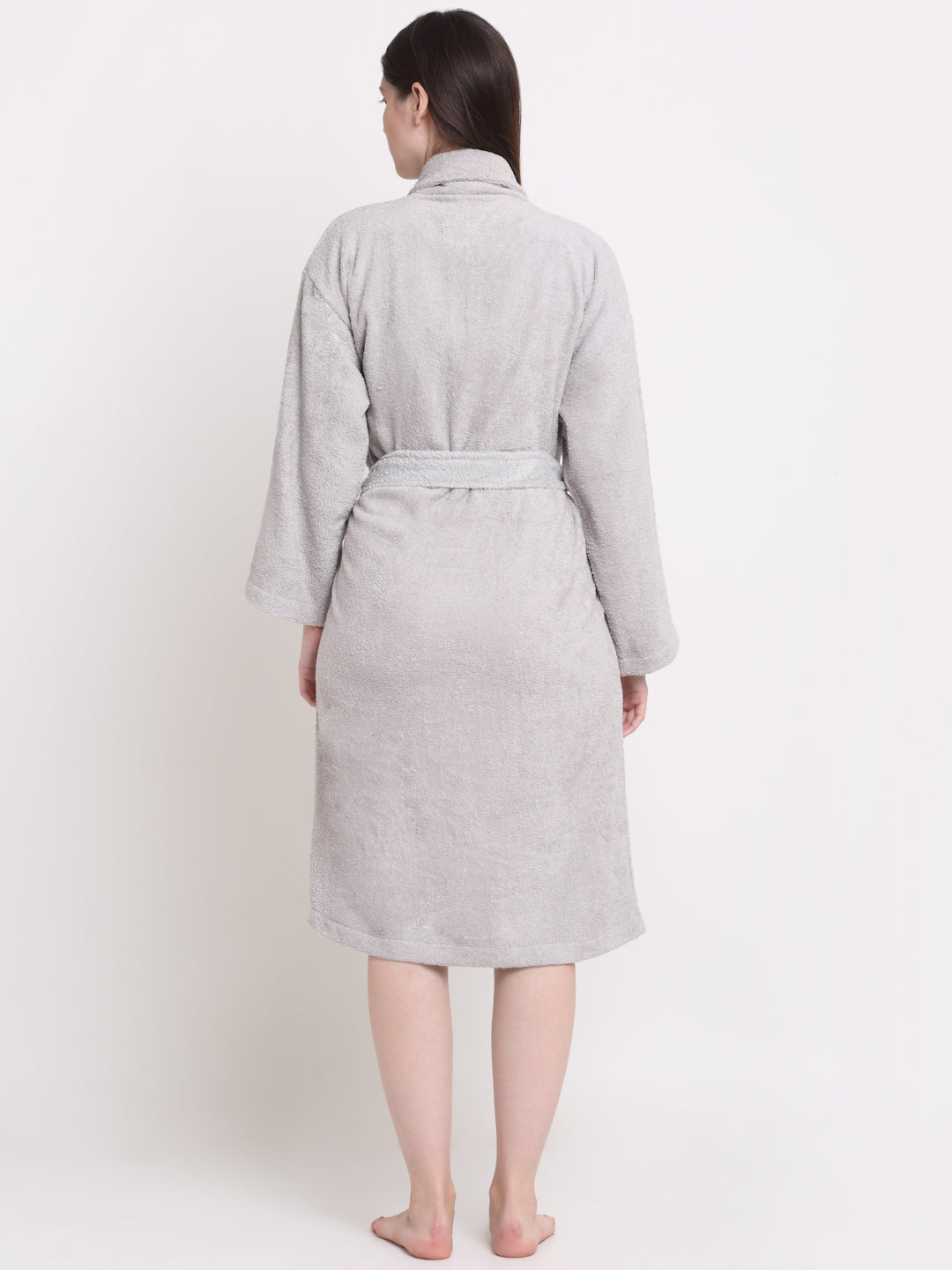Back view of a woman wearing a silver cotton bathrobe with a waist belt