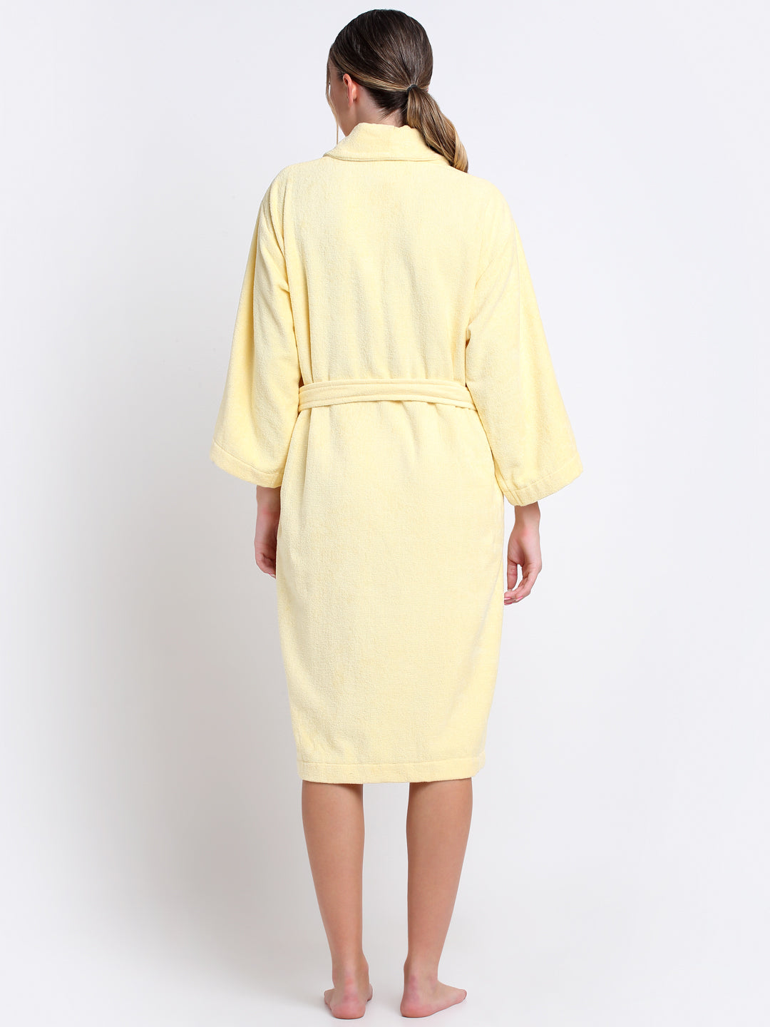Back view of a woman wearing a royal yellow bathrobe with a waist belt
