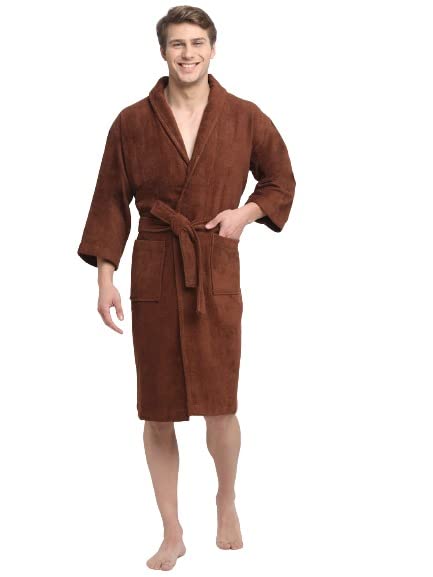 A person standing in a relaxed pose wearing a brown, long-sleeved, unisex cotton bathrobe that reaches up to the knees.