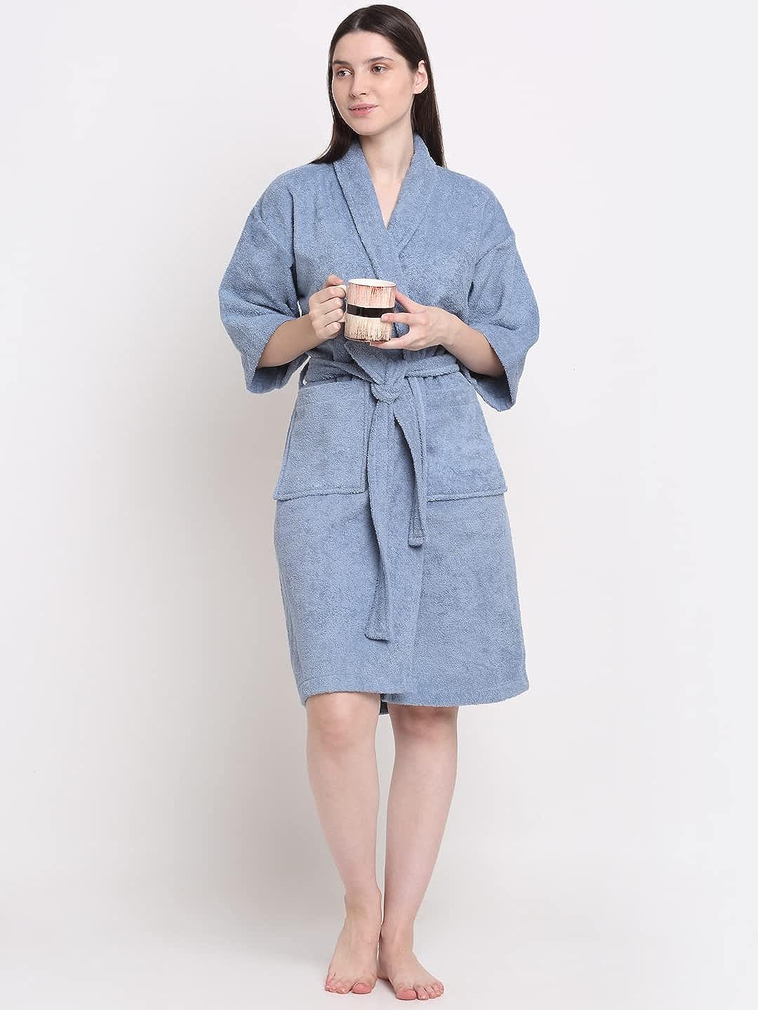 A Woman wearing a Ocean blue 100% cotton bathrobe with a waist belt and front pockets and holding Cup.