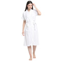A woman wearing a classic white terry cloth bathrobe with a belt tied around the waist, standing on a white background.