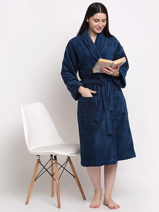 A person standing by a chair wearing a blue cotton bathrobe with a relaxed fit.