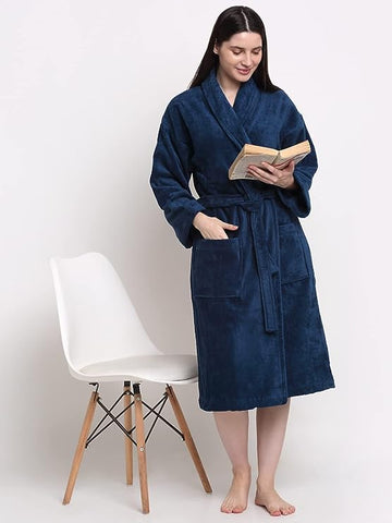 A person standing by a chair wearing a blue cotton bathrobe with a relaxed fit.