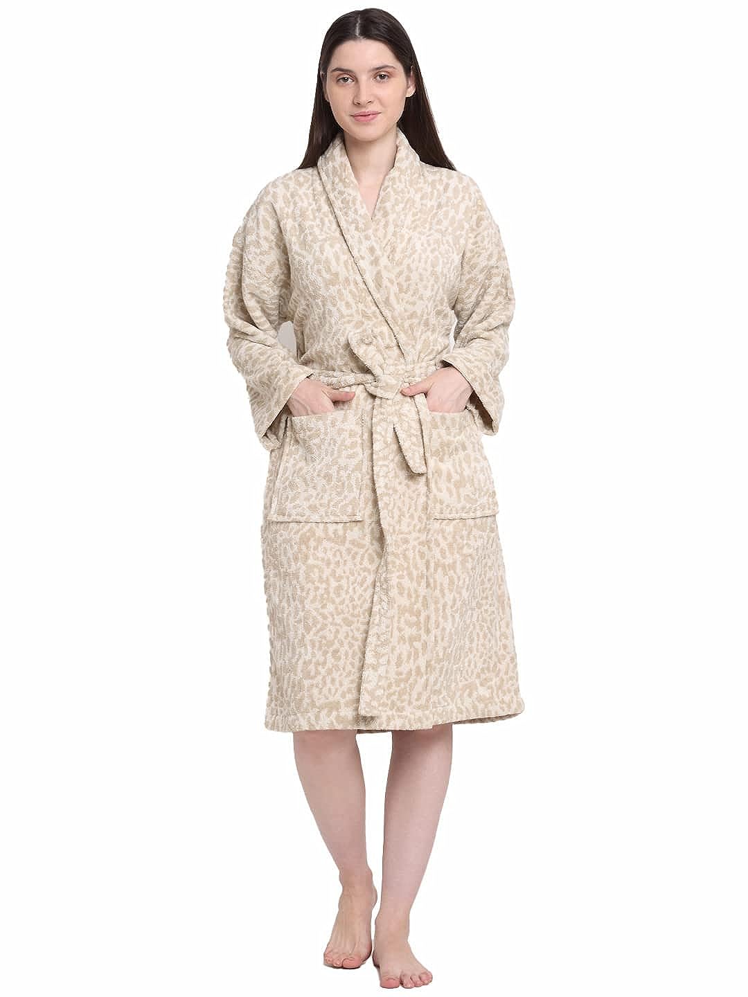 A woman wearing a cream and rust 100% cotton bathrobe with a waist belt and hands in the front pocket