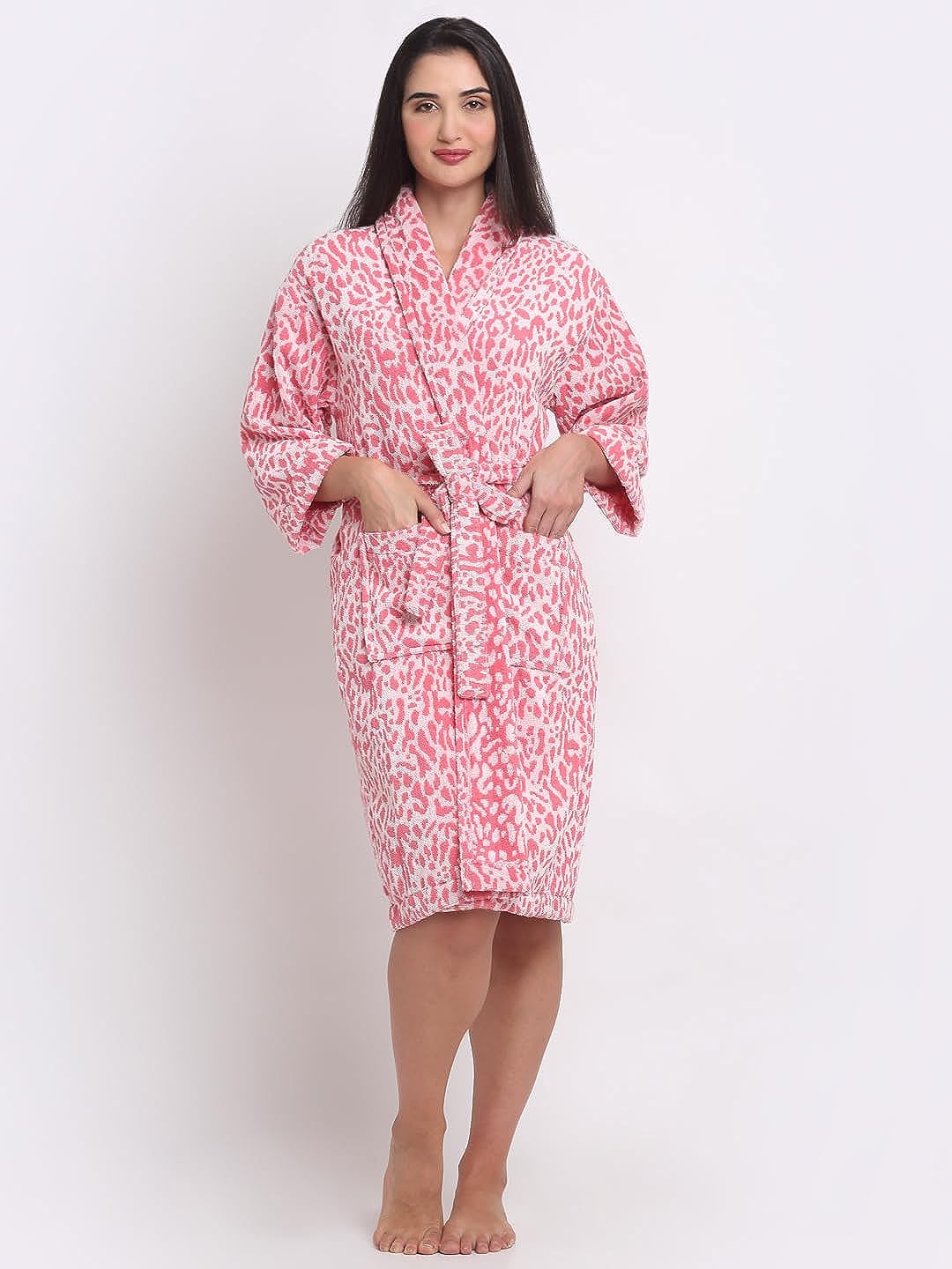 A woman standing and wearing a pink leopard-print bathrobe.