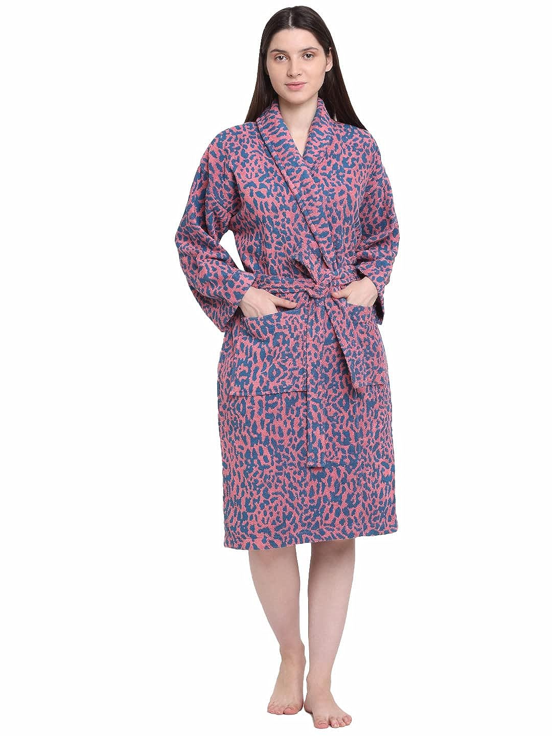 A person standing, wearing a pink and blue dotted 100% cotton unisex bathrobe.